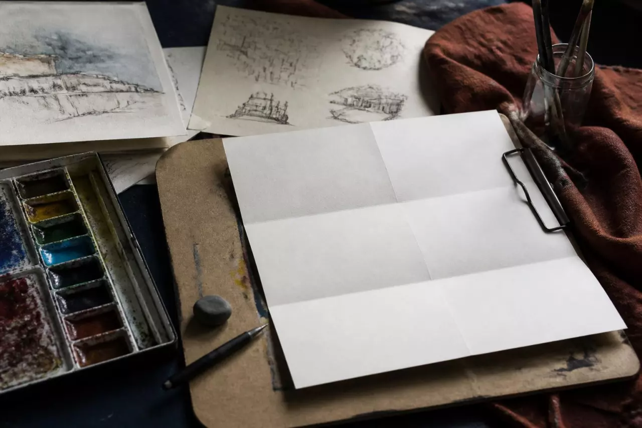 Dessins originaux et contrat papier posés sur une planche à dessin.