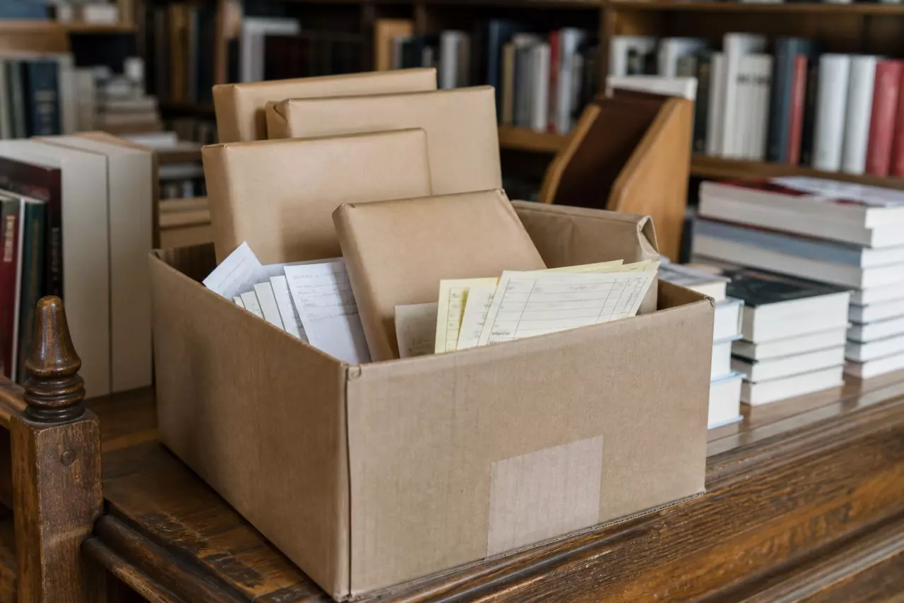 Carton de dépôts et bons de livraison sur le comptoir d’une librairie.