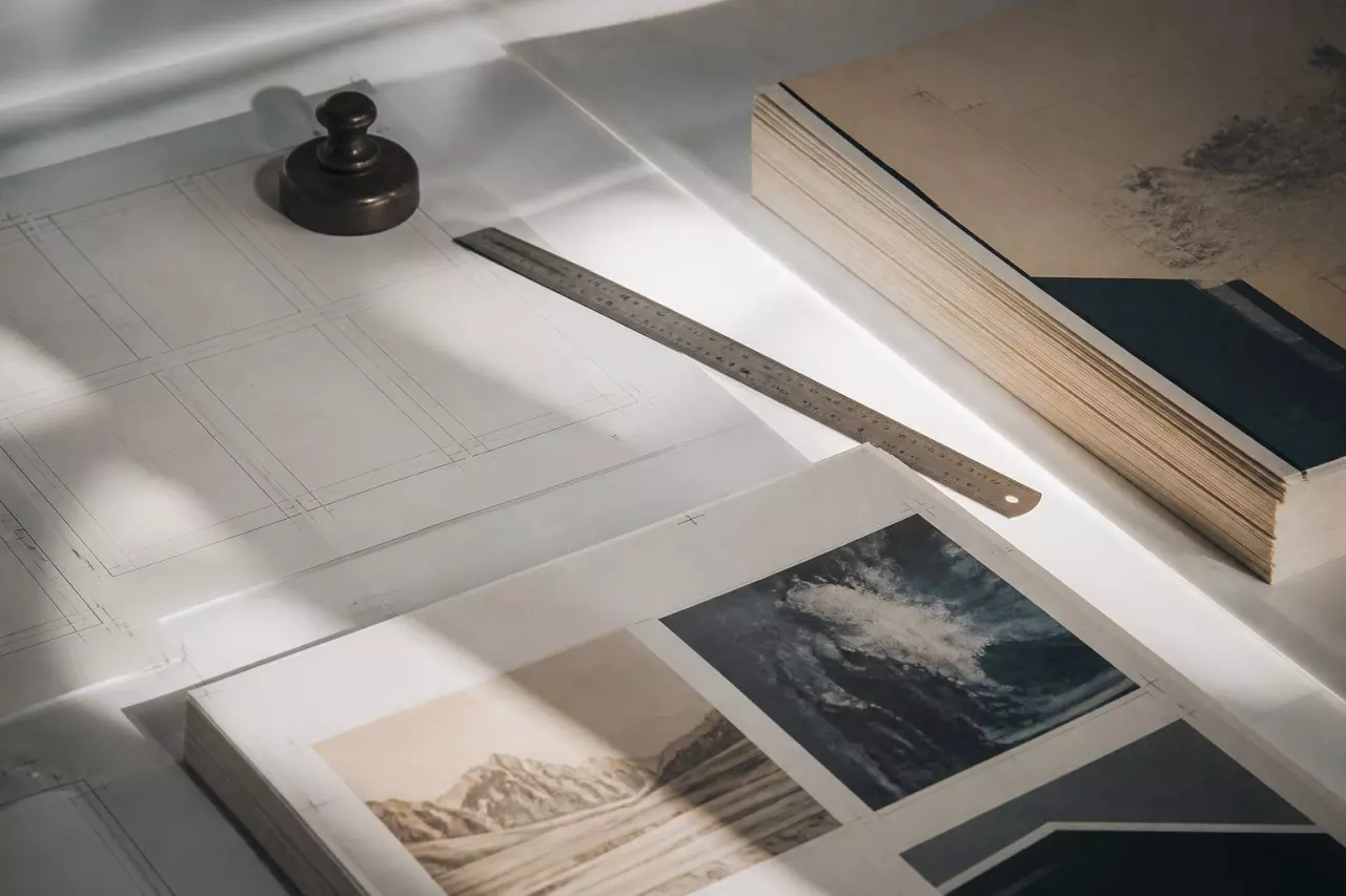 Gabarit de mise en pages, réglet et cahiers imprimés sur une table lumineuse.