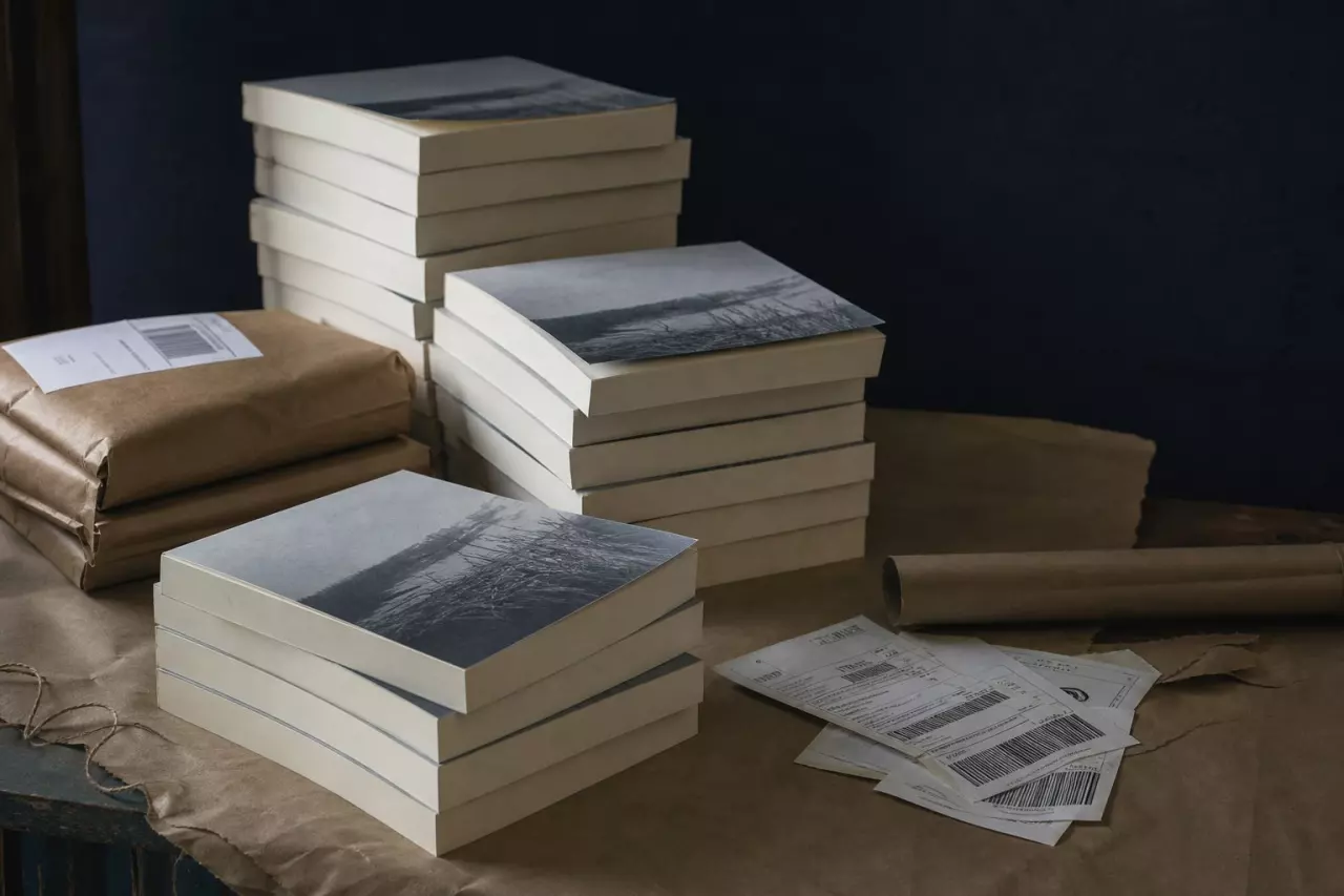 Piles d’exemplaires service de presse et étiquettes d’envoi sur une table.
